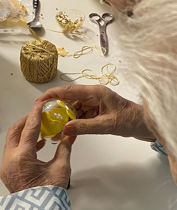 maos seguram uma bola transparente com um coracao amarelo dentro